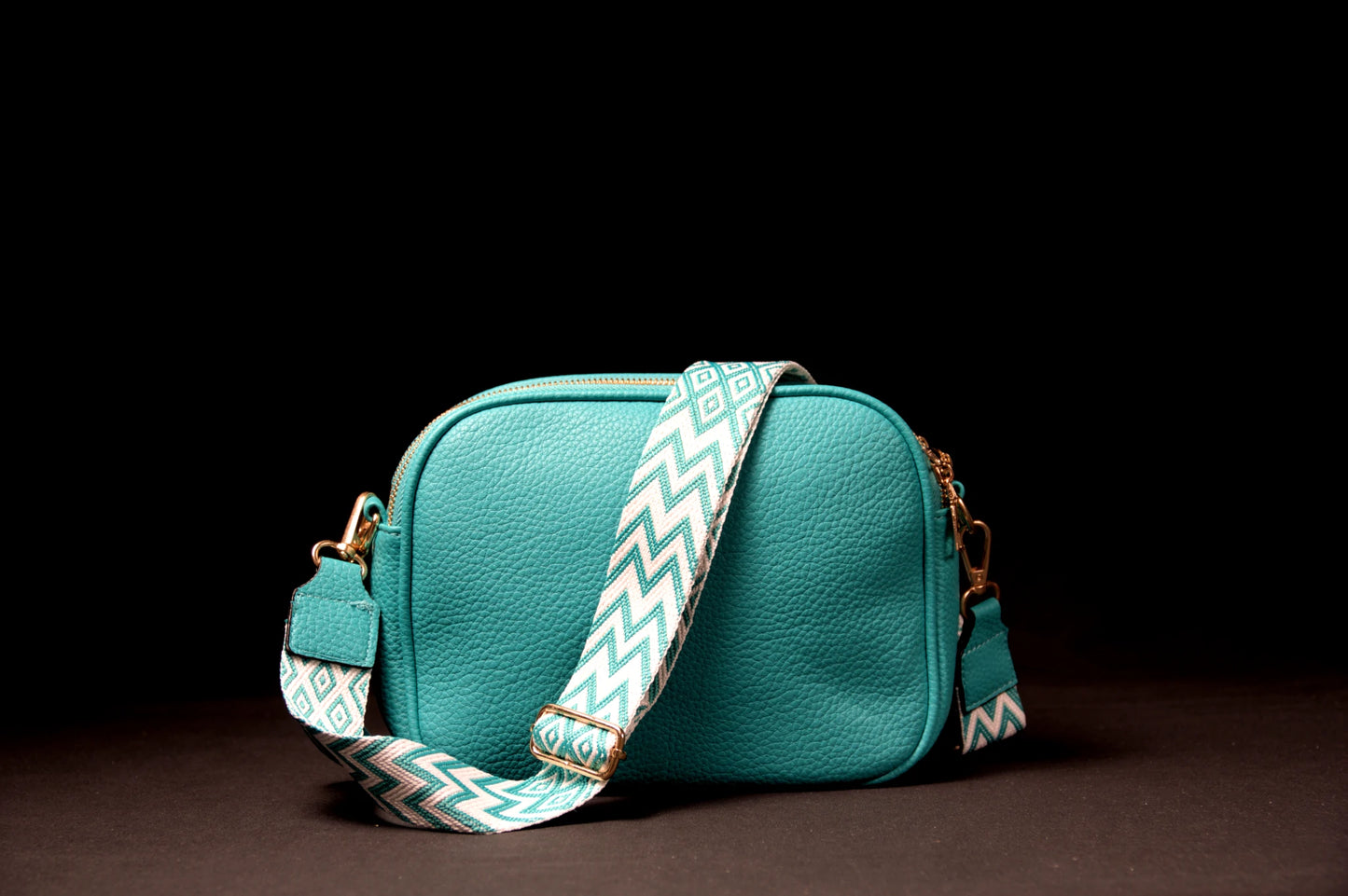 Bandolera con correa de bolso ajustable que presenta un patrón geométrico moderno. Sus 3 bolsillos de apertura superior proporcionan fácil acceso a tus pertenencias, también dispone de un bolsillo interior. Medidas: 23,5 ancho, 18cm alto y 6cm de grosor. El detalle de tener una borla a un lado le agrega un toque de encanto. Disponible en azul turquesa para un toque sereno y en naranja fuerte para destacar